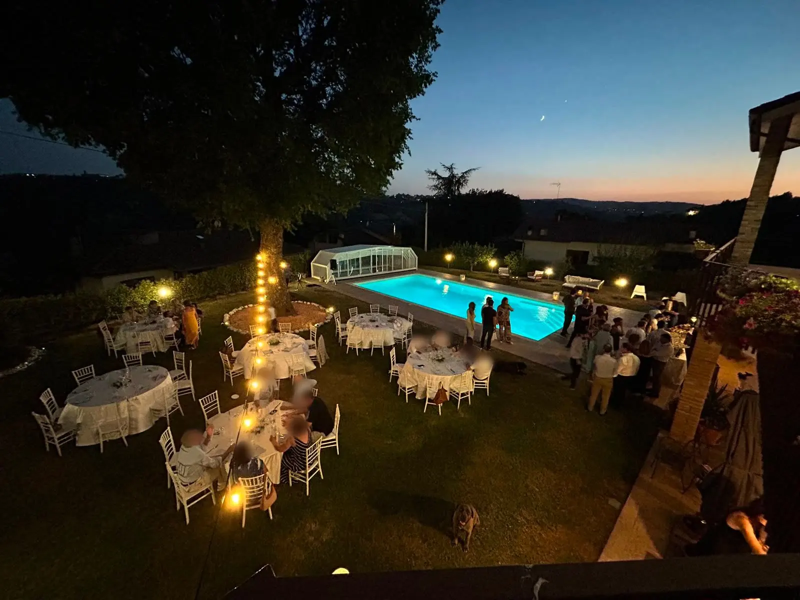 Cena allestita a bordo piscina in una villa privata sulle colline perugine, al calare della sera